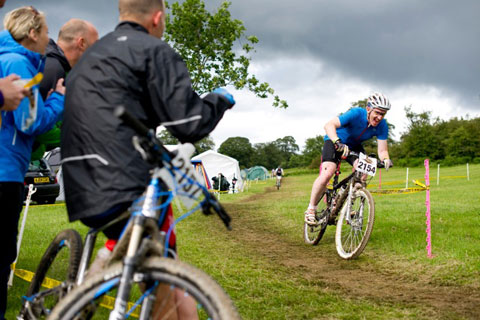 Photograph of a mountain biker with onlookers wathcing